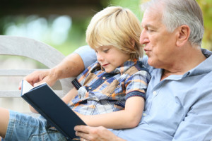 Grandfather reading book with grandson